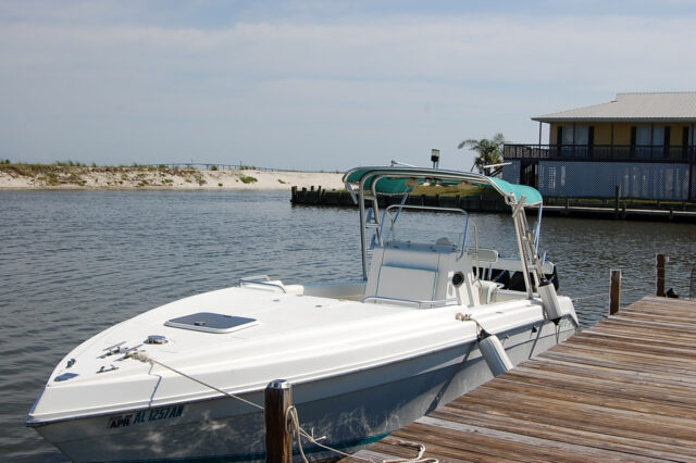 Boat moored at dock next to a Dauphin Island Rental wit Boat Slip